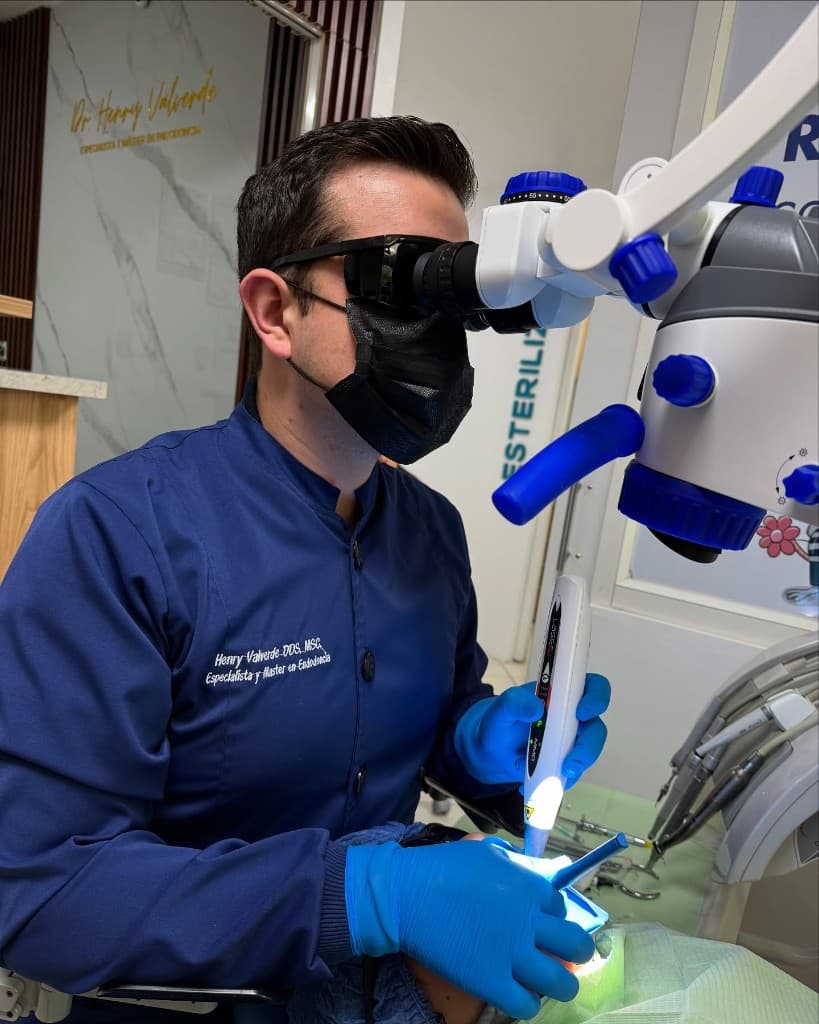 Dr. Henry Valverde trabajando con microscopio y láser en el consultorio